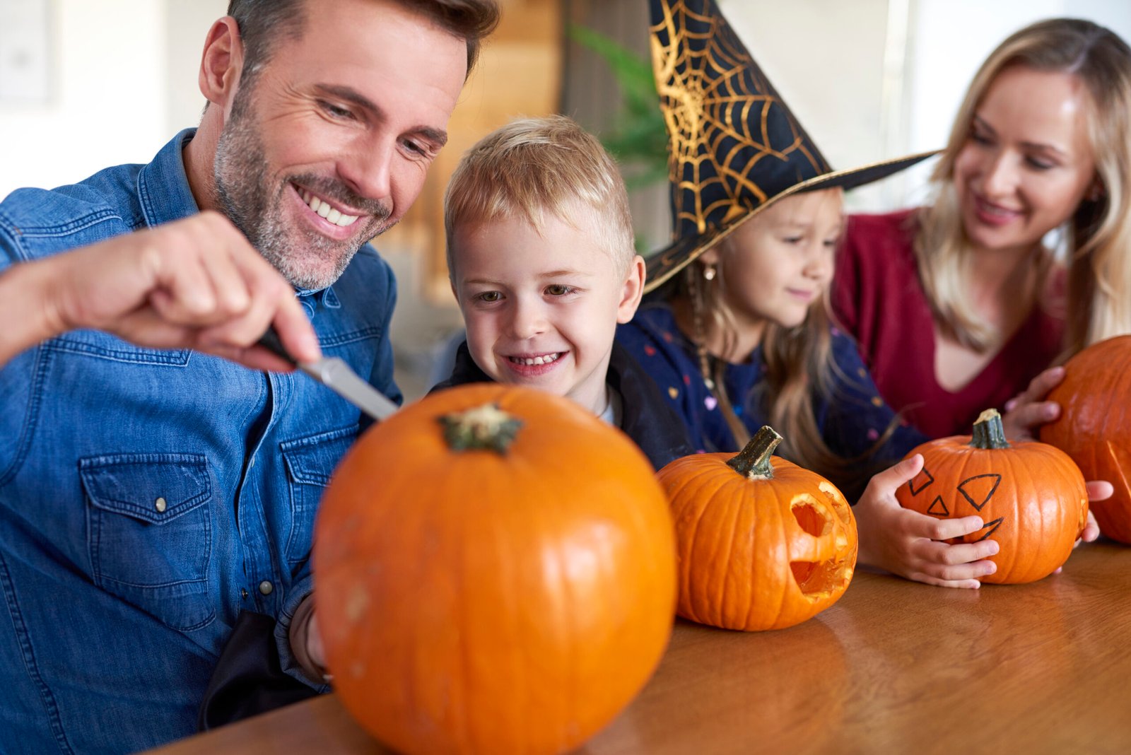 Warm photo of family carving pumpkins together
